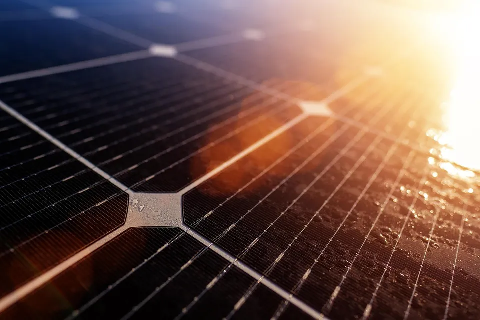 Gros plan sur les cellules d'un panneau photovoltaïque éclairé par le soleil couchant